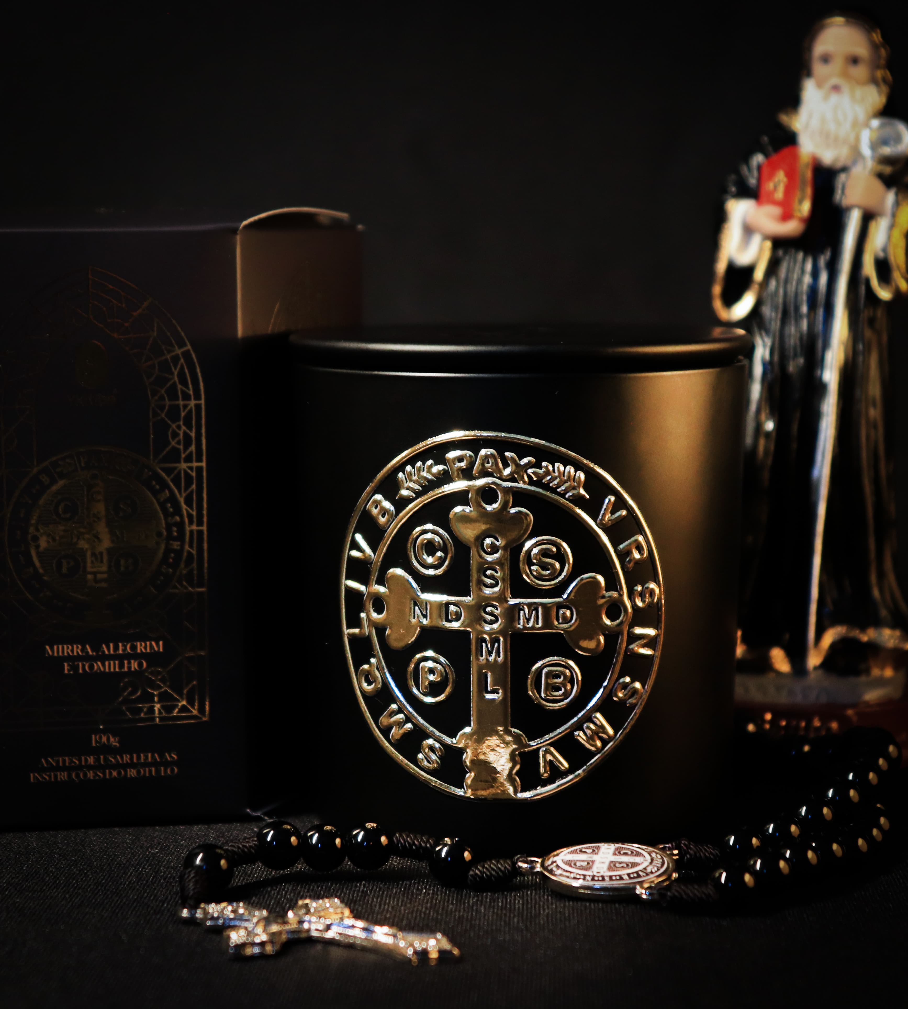 Produto Vela São Bento com terço ao lado da estátua de São Bento